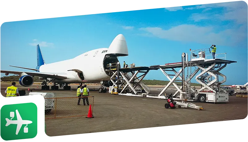Un avión de color blanco con la nariz levantada, tiene un equipo loader conectado para poder descargar carga pesada de la aeronave